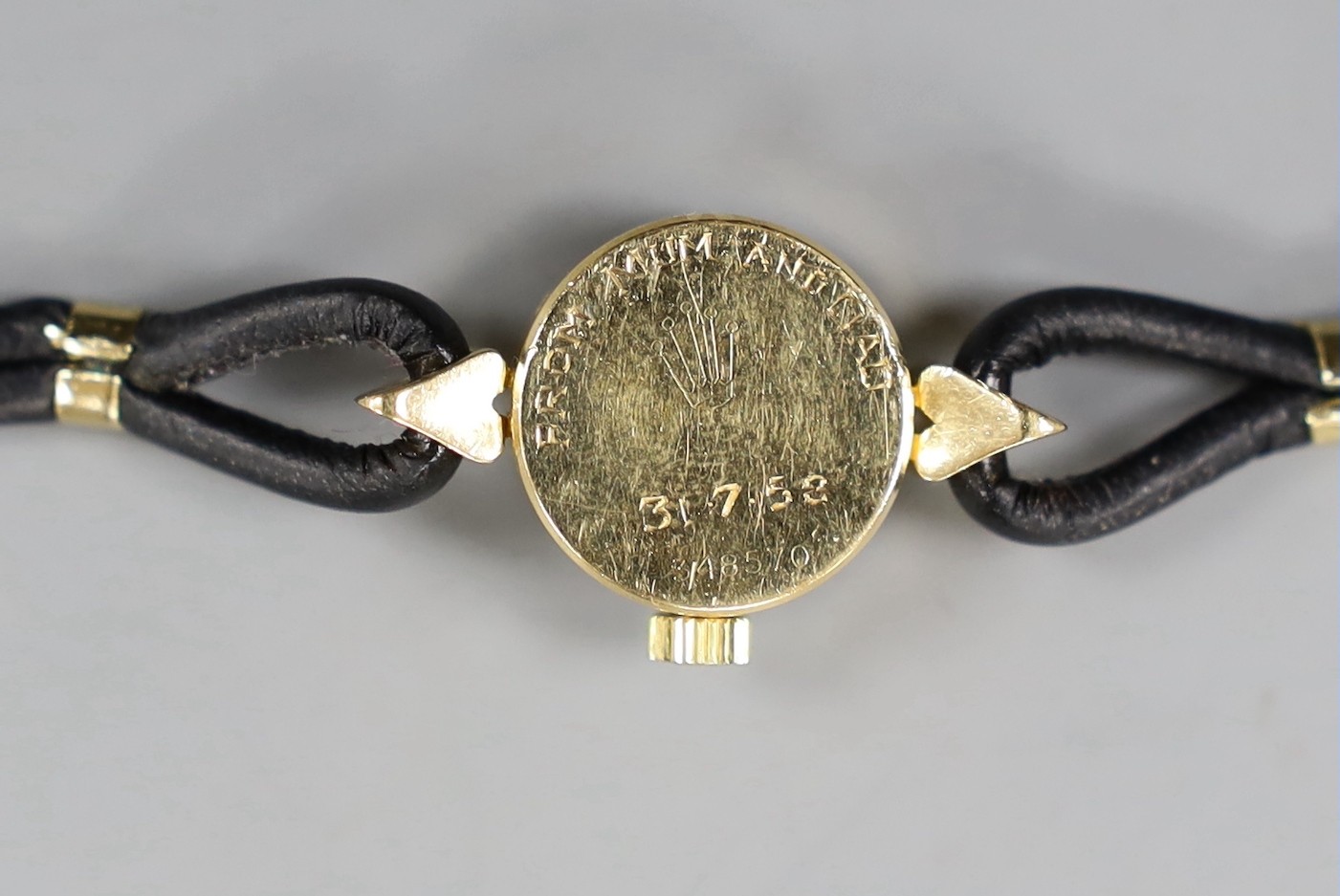 A lady's mid 20th century 750 yellow metal Rolex Orchid manual wind wrist watch, with engraved inscription, on associated leather strap.